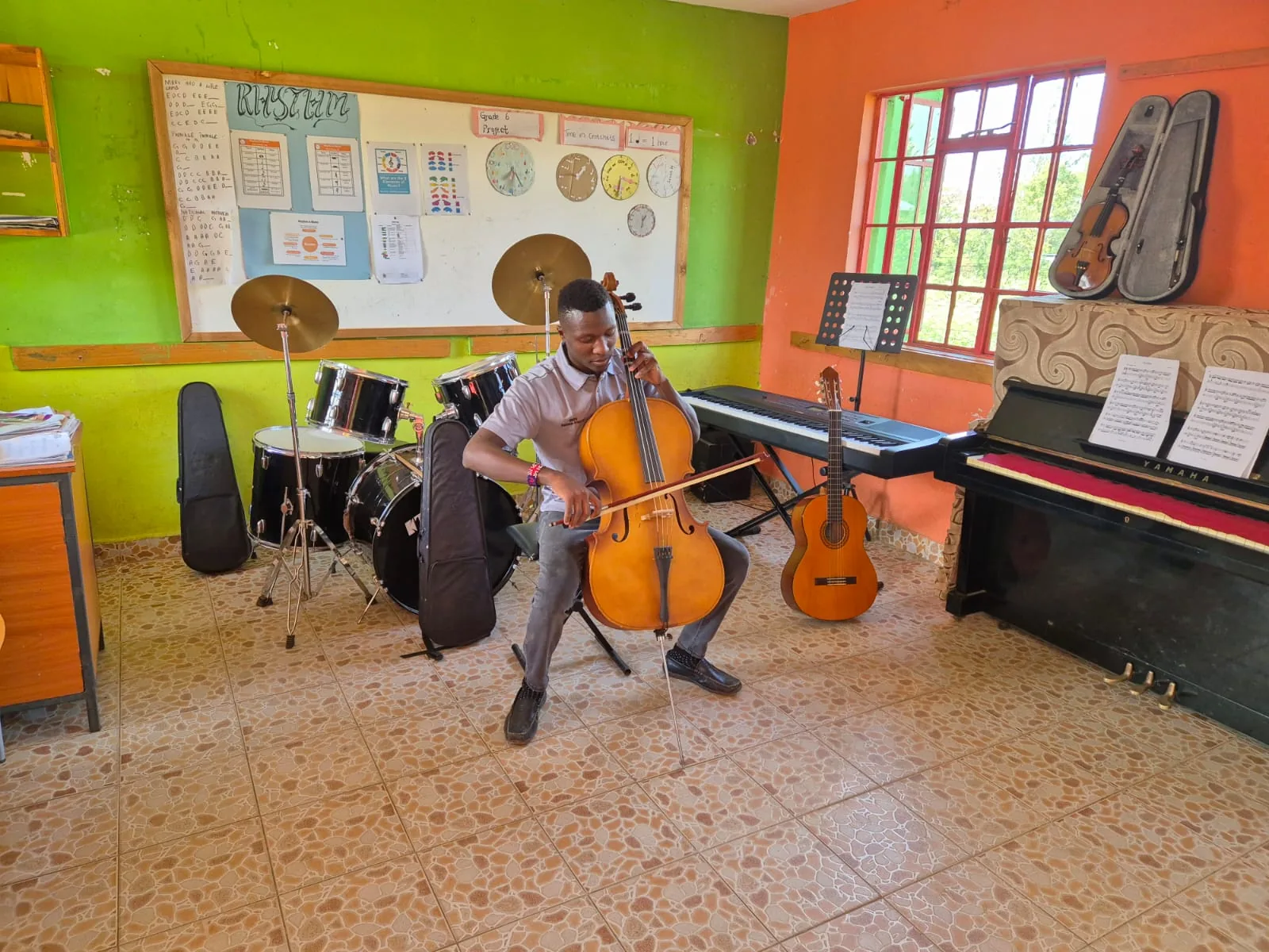 A learner playing the cello in the music room