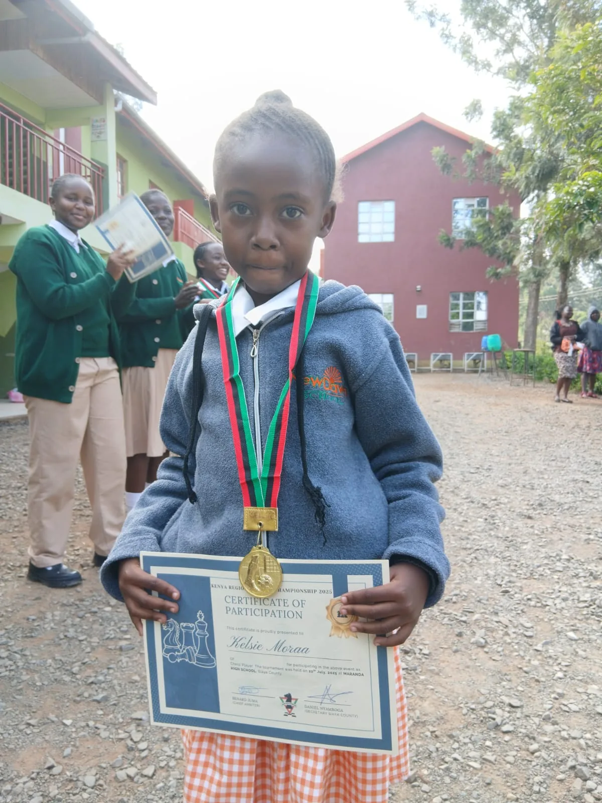 A NewDawn learner proudly wearing medals
